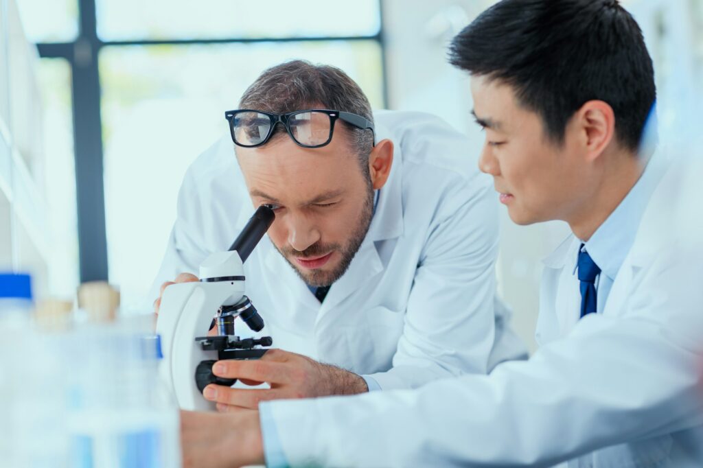 Professional scientists in white coats working together in chemical laboratory